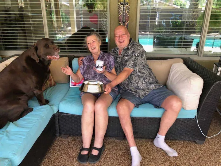 Couple and their dog on a sofa on a newly coated patio.